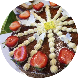 Un fraisier décoré avec des morceaux de nougatine dorée, des fraises rouges brillantes et une présentation soignée idéale pour les grandes occasions.