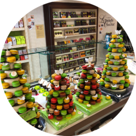 Une superbe pyramide de macarons multicolores, présentée de manière artistique, parfaite pour un événement raffiné.
