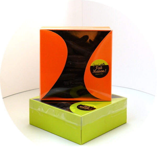 La boîte élégante contenant des orangettes enrobées de chocolat noir, présentée avec soin pour mettre en valeur la texture et la qualité des produits.