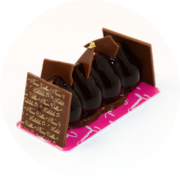 Une présentation élégante du gâteau, avec sa mousse chocolat enrobée d'un croustillant feuilletine, décorée de détails raffinés.