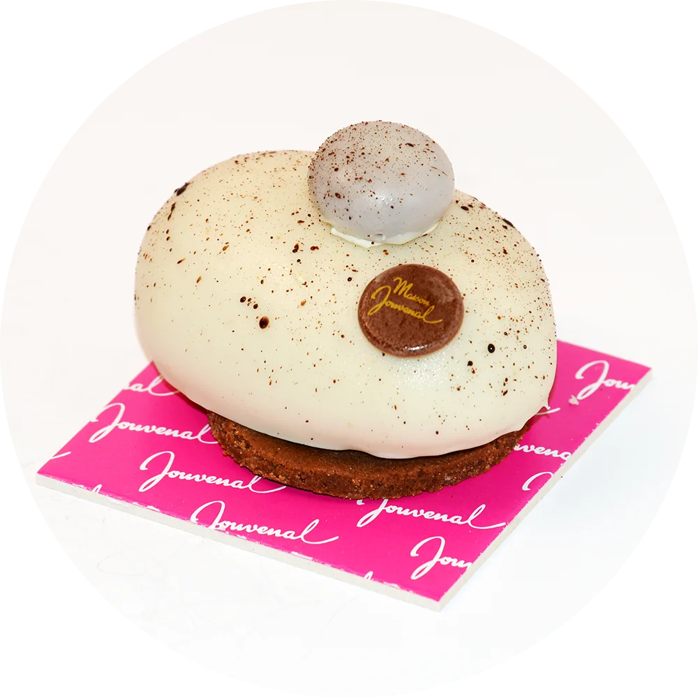 Un gâteau en forme de galet de la chocolaterie Jouvenal. Cette pâtisserie, élégante et raffinée, a une surface lisse et arrondie, rappelant la forme d'un galet. Elle est réalisée avec des ingrédients de qualité, offrant une texture fondante et un goût délicat, parfaite pour les amateurs de pâtisseries artisanales.